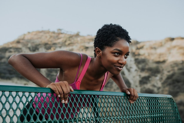 Photo femme qui s'étend contre un banc de parc