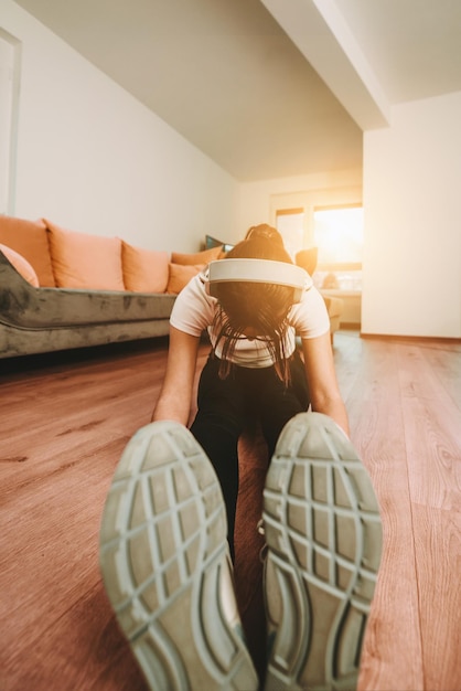 Une femme qui s'étend dans son appartement tôt le matin après la formation reflétant son dévouement à