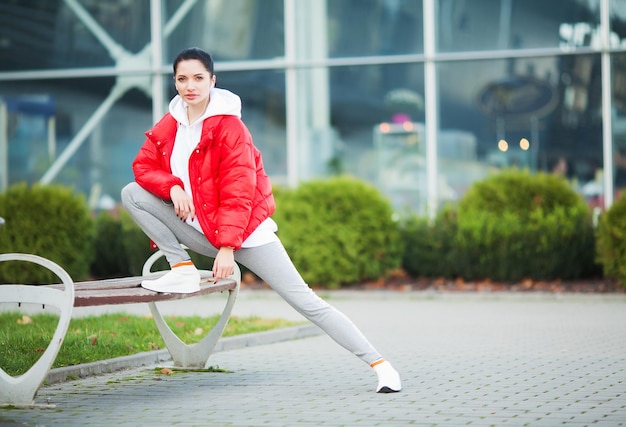 Femme qui s'étend du corps faisant des exercices dans la rue