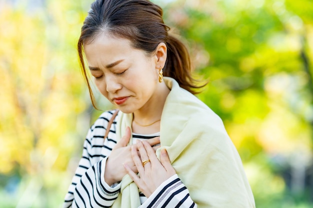 Une femme qui sent des palpitations dans sa poitrine à l'extérieur