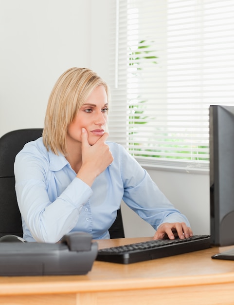 Femme qui travaille devant un écran qui le regarde