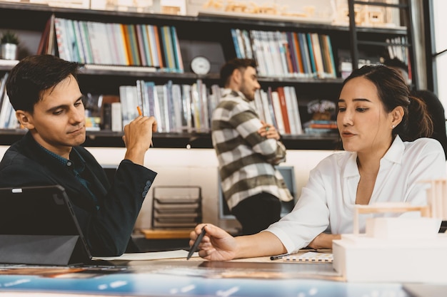 Une femme qui travaille travaille avec une équipe commerciale masculine pour une discussion de projet dans un bureau moderne