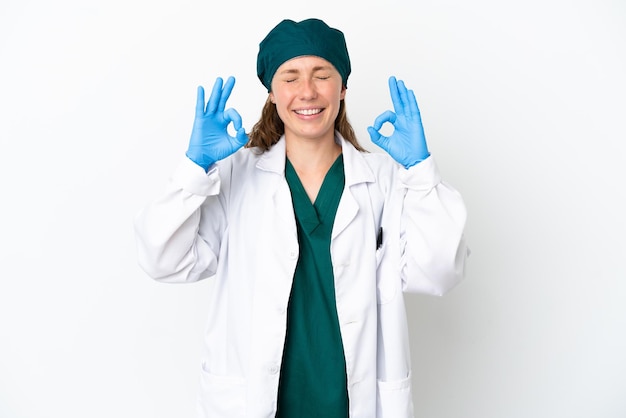 Femme de race blanche de chirurgien en uniforme vert isolé sur fond blanc dans une pose zen