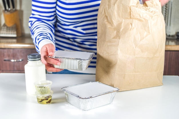 Une femme de race blanche à emporter avec des boîtes de repas à réchauffer et à manger du restaurant. Concept de nourriture de service de livraison de commande à emporter, gros plan