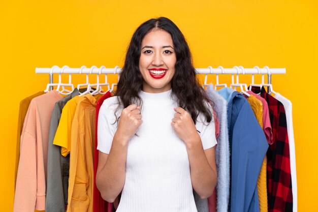 Femme de race mixte dans un magasin de vêtements célébrant une victoire