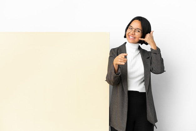 Femme de race mixte jeune entreprise avec une grande bannière sur fond isolé faisant un geste de téléphone et pointant vers l'avant