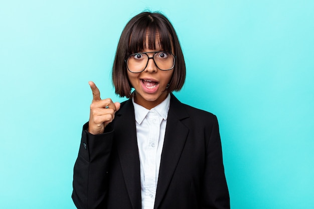 Femme de race mixte jeune entreprise isolée sur fond bleu ayant une idée, concept d'inspiration.