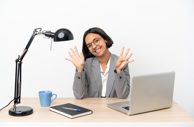 Femme de race mixte jeune entreprise travaillant au bureau comptant neuf avec les doigts