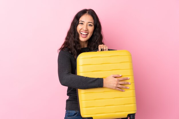 Femme de race mixte en vacances avec valise de voyage