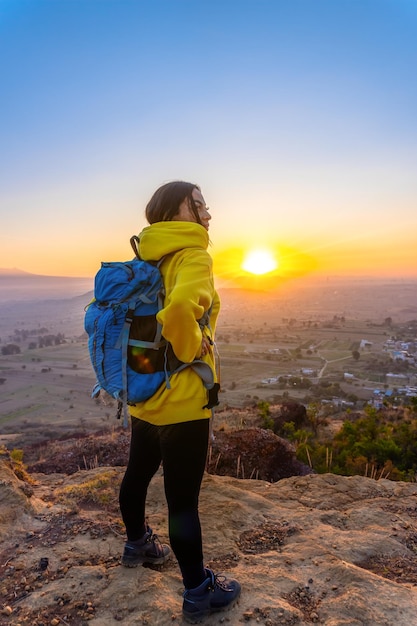 Photo femme en randonnée dans les montagnes et regardant le soleil une vue panoramique