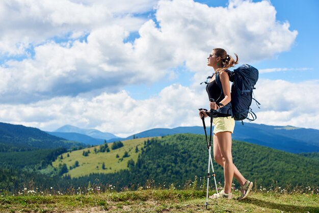 Femme randonneur randonnée sur une colline herbeuse dans les montagnes