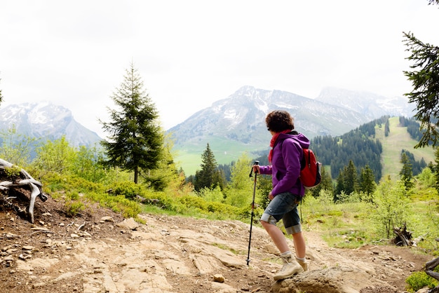 Femme randonneur regarde au sommet de la montagne