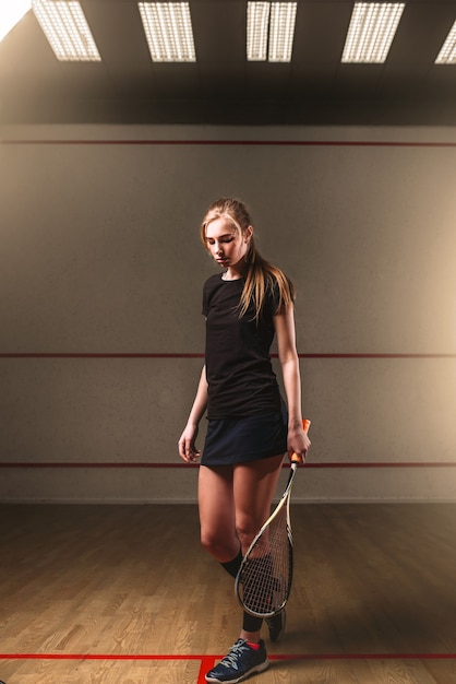 Femme avec raquette de squash, club d'entraînement en salle