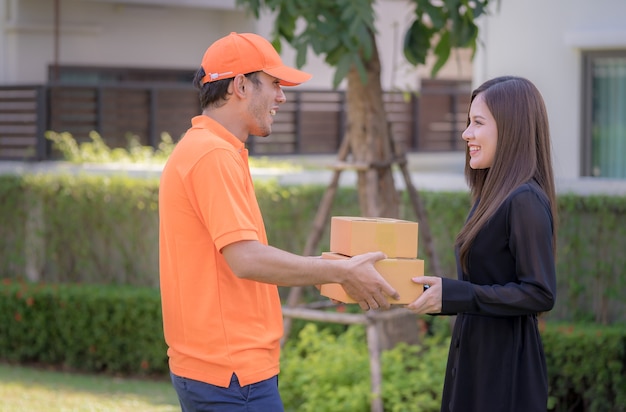 Femme recevant une boîte de livraison du livreur