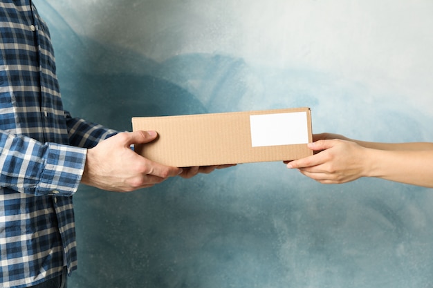 Femme recevant des boîtes de livreur sur fond bleu, espace vide