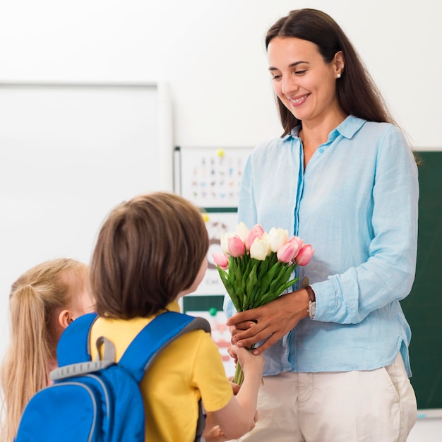 Femme recevant des fleurs de ses élèves