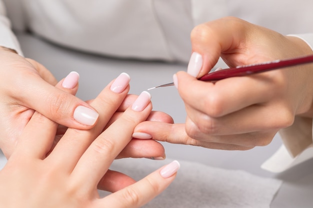 Femme recevant une manucure française par une esthéticienne