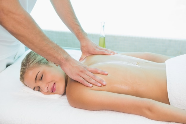 Femme recevant un massage du dos au centre de spa