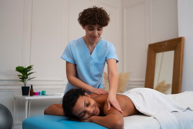 Photo femme recevant un massage du dos dans un centre de réadaptation