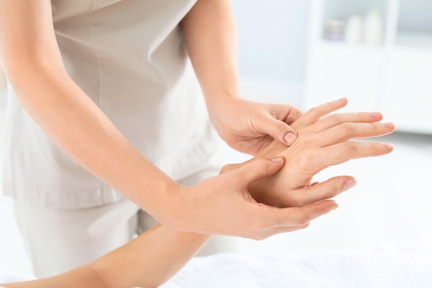 Femme recevant un massage des mains dans un centre de bien-être agrandi