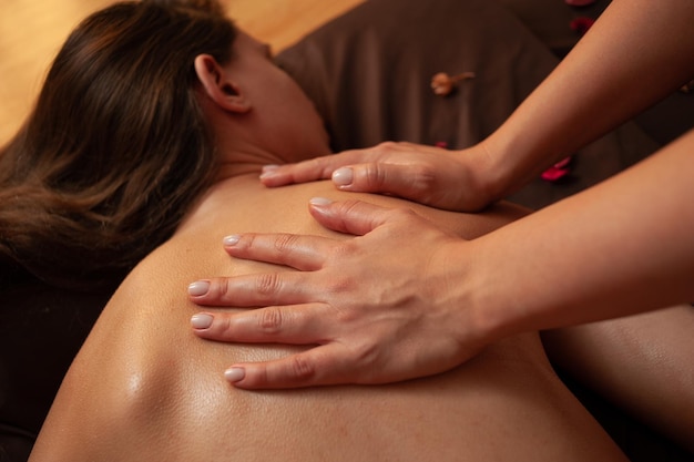 Une femme recevant un massage d'un massothérapeute du spa.