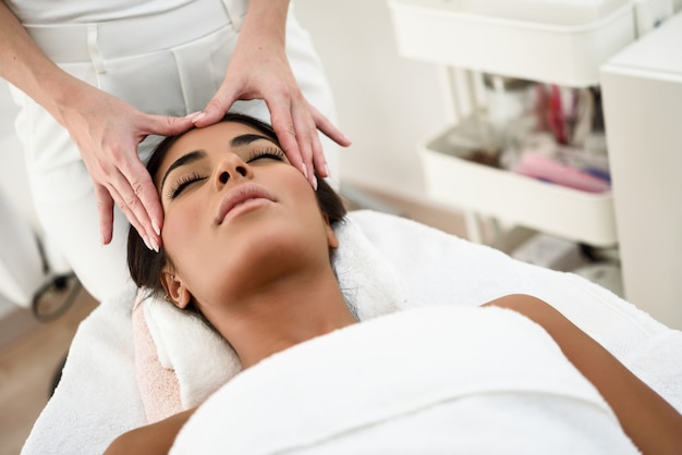 Femme recevant un massage de la tête dans un centre de bien-être spa.