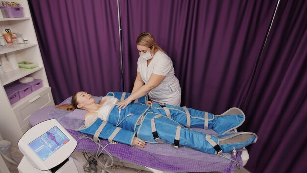 Femme recevant une pressothérapie anticellulite massage lymphatique machine de drainage cosmétologie matérielle