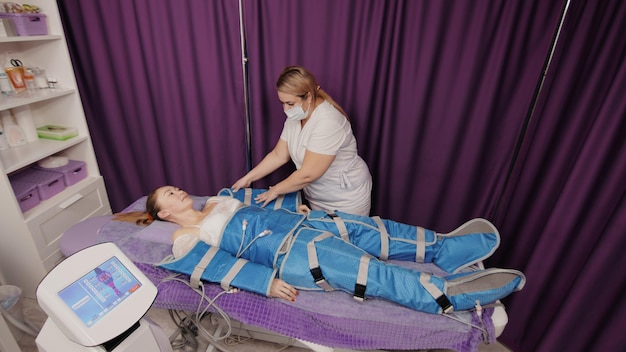 Femme recevant une pressothérapie anticellulite massage lymphatique machine de drainage matériel appareil de cosmétologie dans un salon de spa