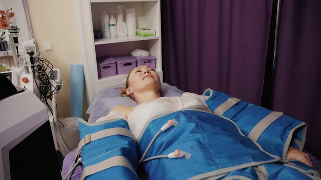 Femme recevant une pressothérapie anticellulite massage lymphatique machine de drainage matériel appareil de cosmétologie dans un salon de spa
