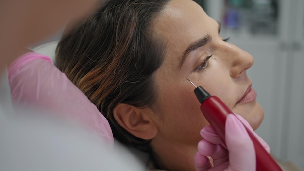 Femme recevant une procédure de rajeunissement avec un appareil ultraviolet en gros plan de la clinique