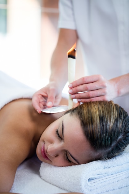 Femme recevant un traitement de bougie d'oreille