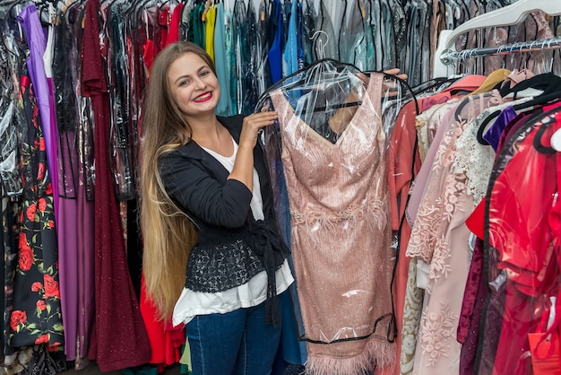 Femme à la recherche d'une robe de soirée en magasin