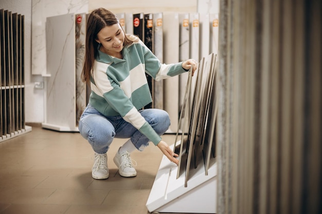 Femme à la recherche de tuiles au marché du bâtiment