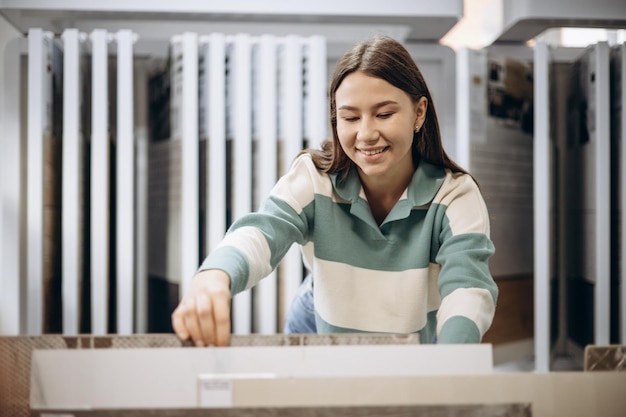 Femme à la recherche de tuiles au marché du bâtiment