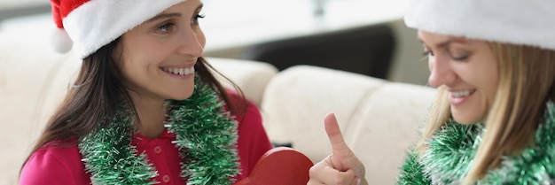 Une femme reçoit un cadeau de sa sœur dans une boîte rouge, un nouveau modèle de smartphone