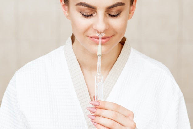 La femme reçoit une inhalation nasale de Maholda par de l'huile essentielle dans le nez au spa.