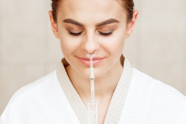 La femme reçoit l'inhalation nasale.