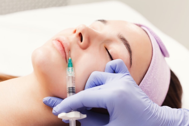 La femme reçoit des injections faciales de beauté, en gros plan. Traitement anti-âge, nourrissant et vitaminé au salon spa. Cosmétologie esthétique