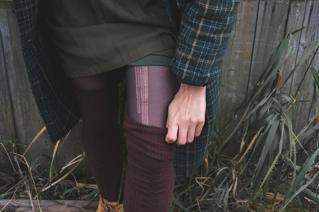 Une femme redresse son bas à l'extérieur par une froide journée d'automne