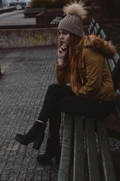 Photo une femme réfléchie assise sur un banc.