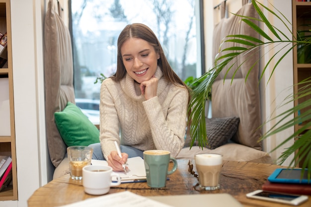 Une Femme Réfléchie, Buvant Beaucoup De Café Tout En Faisant Un Travail Créatif