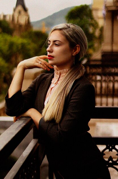 Photo une femme réfléchie détournant le regard alors qu'elle se tient près de la balustrade.