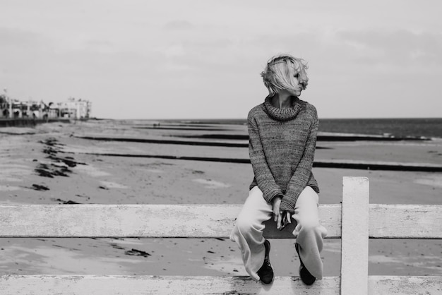 Une femme réfléchie est assise sur l'océan Femme d'âge moyen Concept de crise de dépression Photo en noir et blanc