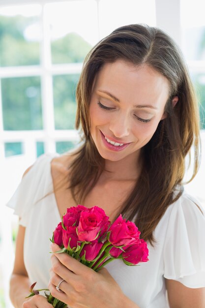 Femme réfléchie avec des fleurs à la maison