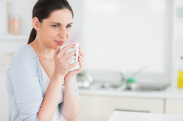 Femme réfléchie tenant une tasse