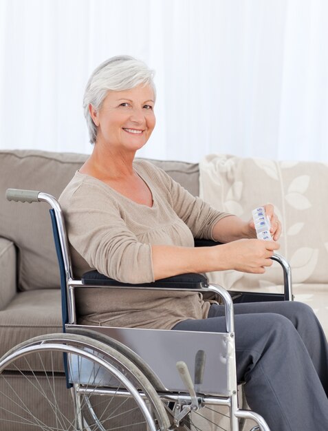 Femme regardant la caméra dans son fauteuil roulant