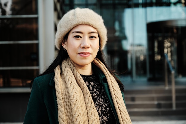 Femme regardant la caméra tout en posant à l'extérieur de l'immeuble de bureaux.