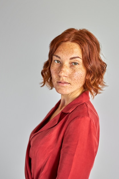 Femme regardant avec confiance la caméra, femme sérieuse aux cheveux courts et mignonnes taches de rousseur posant