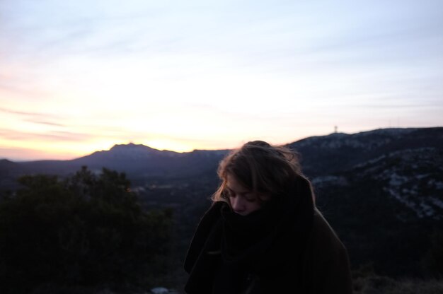 Une femme regardant le coucher de soleil