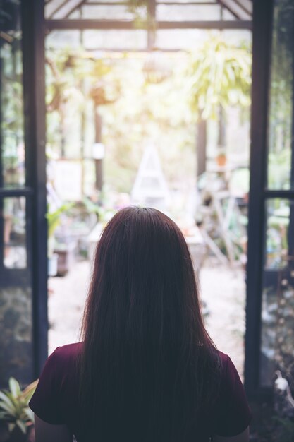 femme regardant dans la maison de verre